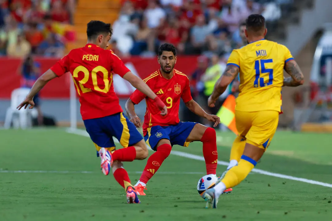 El defensa de la selecci&oacute;n andorrana de f&uacute;tbol Mois&eacute;s San Nicol&aacute;s (d) pelea un bal&oacute;n con Pedri (i) y Ayoze P&eacute;rez, ambos de Espa&ntilde;a, durante el partido amistoso que Espa&ntilde;a y Andorra disputan este mi&eacute;rcoles en el estadio Nuevo Vivero, en Badajoz. EFE/Julio Mu&ntilde;oz
