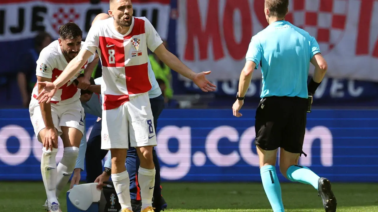 El croata Mateo Kovacic habla con el &aacute;rbitro Francois Letexier en Hamburgo, Alemania. EFE/EPA/ABEDIN TAHERKENAREH
