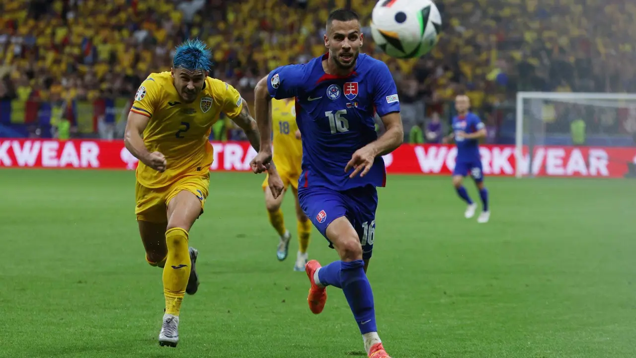El defensa eslovaco David Hancko (c) y el rumano Andrei Ratiu buscan el bal&oacute;n durante el partido del grupo E que han jugado Eslovaquia y Ruman&iacute;a en Fr&aacute;nkfort, Alemania. EFE/EPA/MOHAMMED BADRA